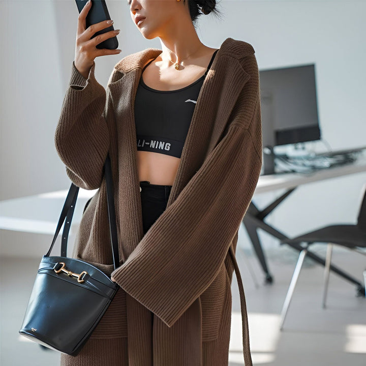 Femme portant un kimono marron, un sac noir et un soutien-gorge de sport. Vente de kimonos de notre collection en ligne.