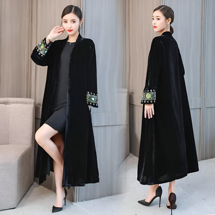 Kimono long noir en velours avec broderies colorées aux manches porté par une femme élégante. Vêtements traditionnels japonais disponibles à l'achat.