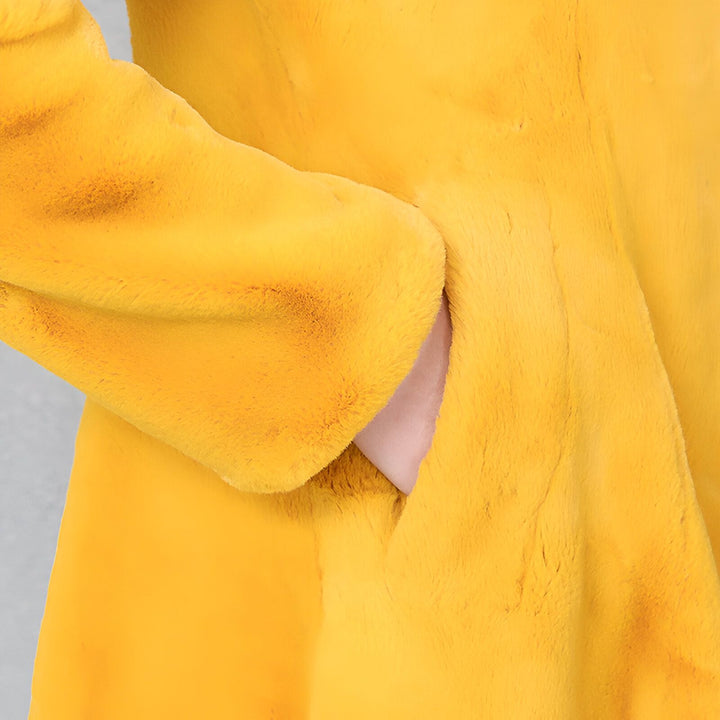 Détail d'un kimono en fausse fourrure jaune. On voit la manche et une main dans la poche. Vêtements de style japonais.