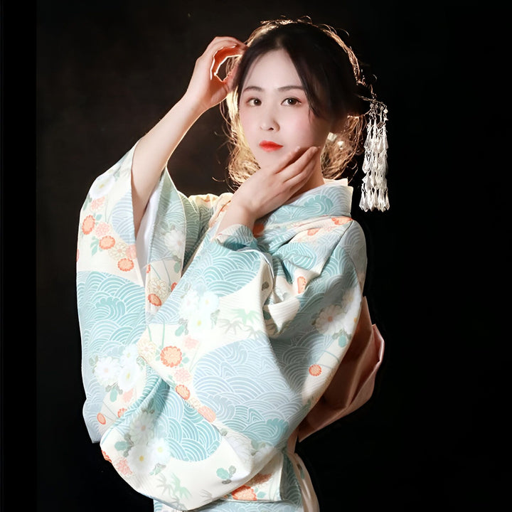 Femme portant un kimono traditionnel japonais à motifs floraux et vagues. Accessoire de cheveux avec pendentifs. Vente de kimonos en ligne.