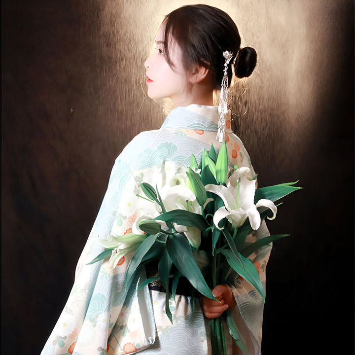 Femme asiatique en kimono portant des lys blancs. Vente de kimonos traditionnels et modernes japonais. Accessoires pour kimono. Élégance et raffinement japonais.