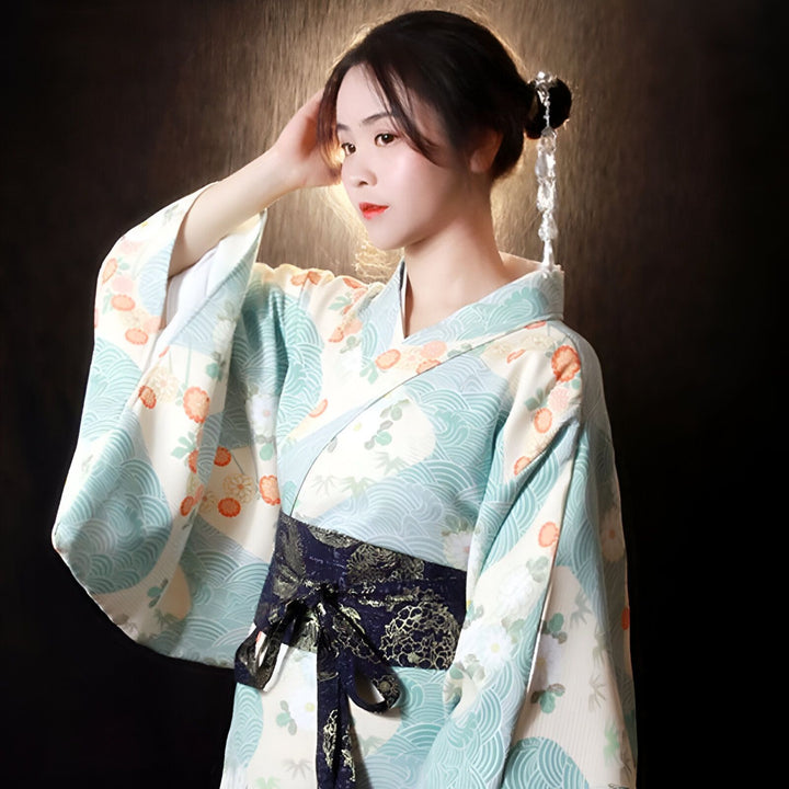 Femme portant un kimono traditionnel japonais bleu et blanc avec motif floral et obi bleu marine. Bijou de cheveux délicat. Vêtements japonais authentiques.