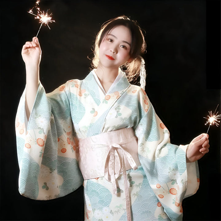 Femme souriante en kimono à motifs tenant des feux de Bengale. Vente de kimonos japonais traditionnels et modernes pour femmes et hommes.