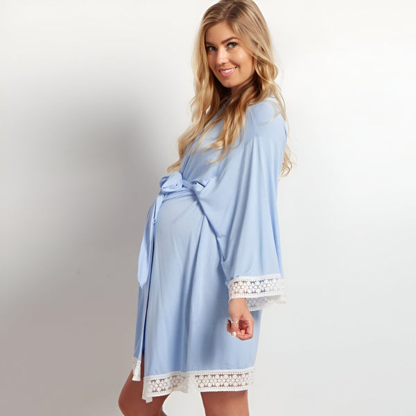 Femme enceinte portant un kimono bleu clair avec des bordures en dentelle blanche. Vente de kimonos pour femmes.