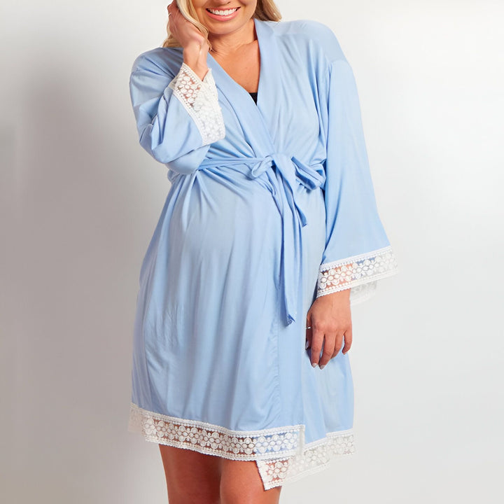 Femme enceinte portant un kimono bleu ciel avec bordures en dentelle blanche. Kimono confortable et élégant pour la maternité. Découvrez notre collection de kimonos.