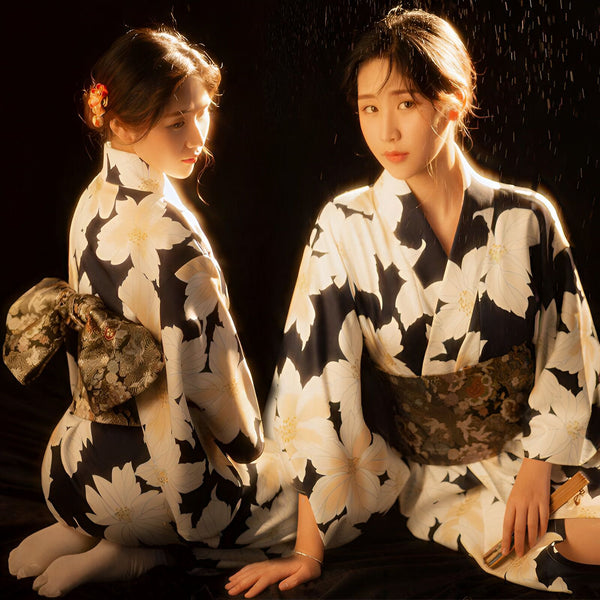 Deux femmes portant des kimonos traditionnels à motifs floraux. Vente de kimonos japonais authentiques. Mode et élégance japonaises. Découvrez notre collection de kimonos uniques.