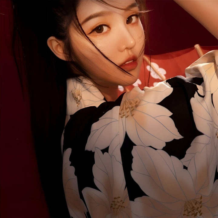 Jeune femme portant un kimono fleuri noir et blanc. Vente de kimonos traditionnels et modernes.