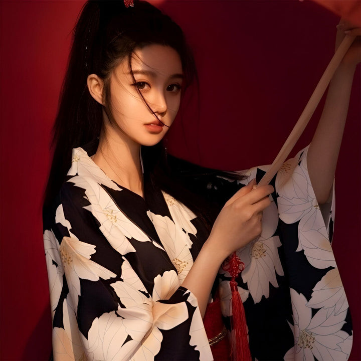 Jeune femme portant un kimono fleuri noir et blanc. Kimonos traditionnels et modernes à vendre. Boutique de kimonos en ligne.