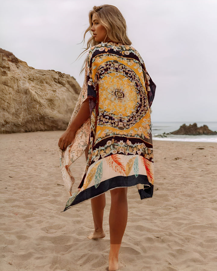 Femme blonde portant un kimono coloré sur la plage. Kimonos à motifs originaux à vendre. Collection de kimonos uniques. Tendance mode estivale.
