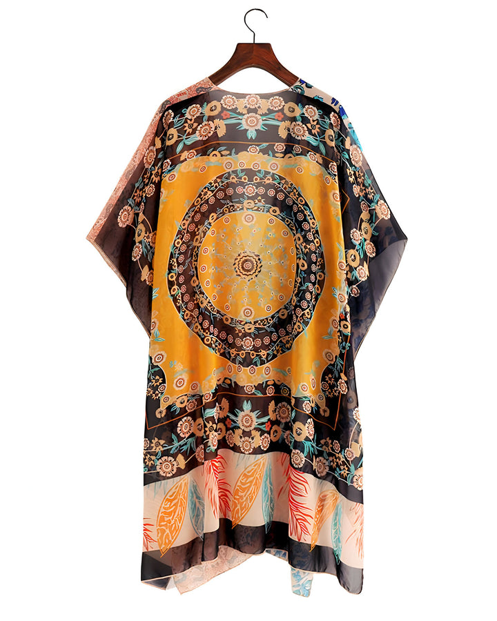 Kimono fleuri jaune et noir sur un cintre. Vêtement ample et léger, idéal comme accessoire de mode ou vêtement de plage. Motifs circulaires et floraux, style bohème chic.