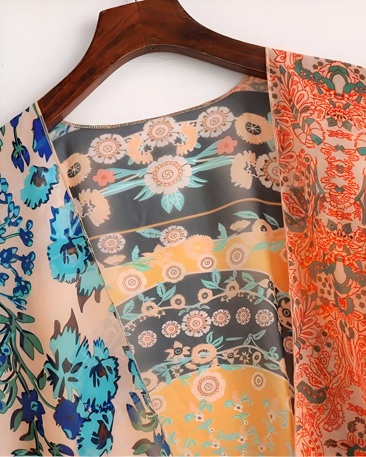 Kimono femme à motifs floraux variés sur cintre en bois. Vêtement léger et coloré, idéal pour un style bohème. Disponible dans notre collection de kimonos.
