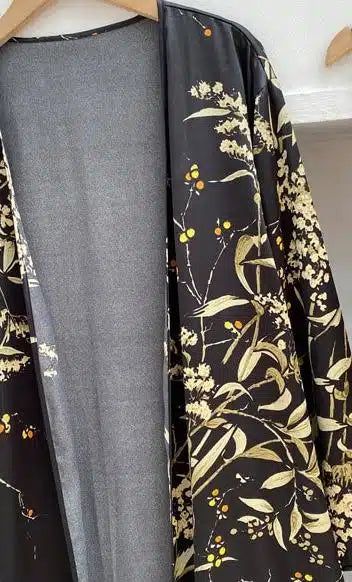 Kimono noir à motifs floraux dorés, vêtement ample et léger. Idéal pour ajouter une touche d'élégance à votre tenue. Découvrez notre collection de kimonos uniques.