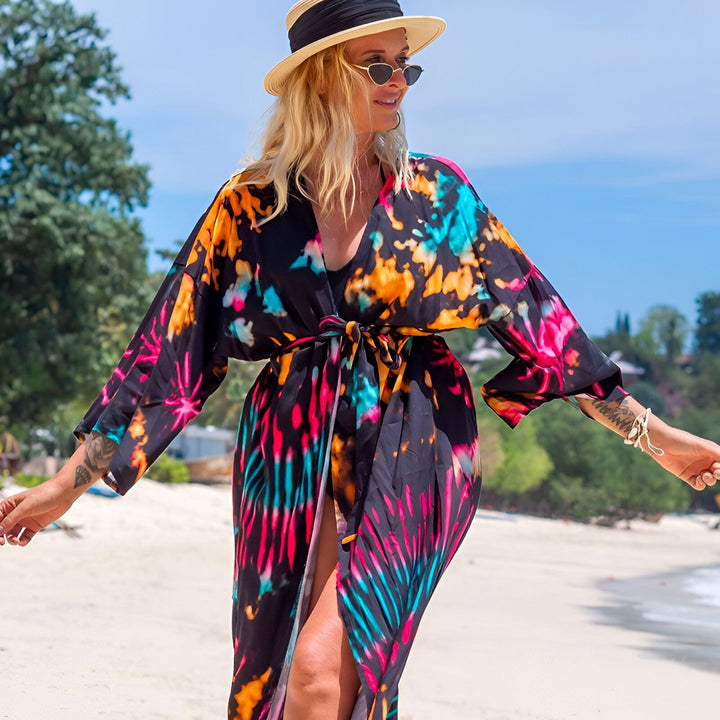 Femme portant un kimono coloré sur la plage. Kimonos pour femmes, vêtements de plage tendance. Découvrez notre collection de kimonos uniques.