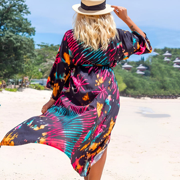 Femme portant un kimono coloré sur la plage, dos tourné. Chapeau de paille. Kimonos de plage à motifs éclatants. Vêtements d'été style kimono.