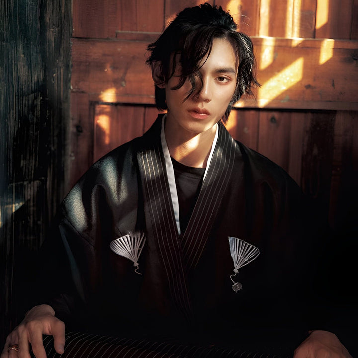 Homme portant un kimono noir à rayures. Vêtements traditionnels japonais. Boutique de kimonos en ligne. Mode asiatique, style kimono. Élégance et confort dans un kimono authentique.