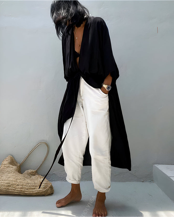 Femme portant un kimono noir élégant avec pantalon blanc. Mode décontractée avec style. Découvrez notre collection de kimonos.