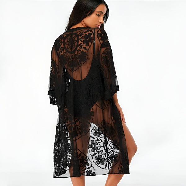 Femme portant un kimono noir en dentelle florale transparente, dos tourné. Kimono élégant et léger, parfait pour la plage ou comme vêtement d'intérieur. Découvrez notre collection de kimonos en dentelle.