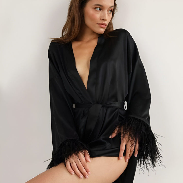 Femme en kimono noir élégant avec détails en plumes. Kimono de luxe, vêtement d'intérieur chic. Boutique en ligne de kimonos.