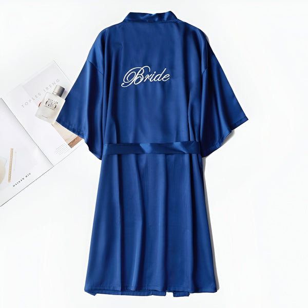 Kimono bleu en satin pour future mariée, avec l'inscription "Bride" brodée au dos. Vêtement de détente élégant, idéal pour la préparation du mariage. Notre collection de kimonos pour femmes.
