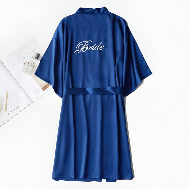 Kimono bleu en satin pour future mariée, avec l'inscription "Bride" brodée au dos. Vêtement de détente élégant, idéal pour la préparation du mariage. Notre collection de kimonos pour femmes.