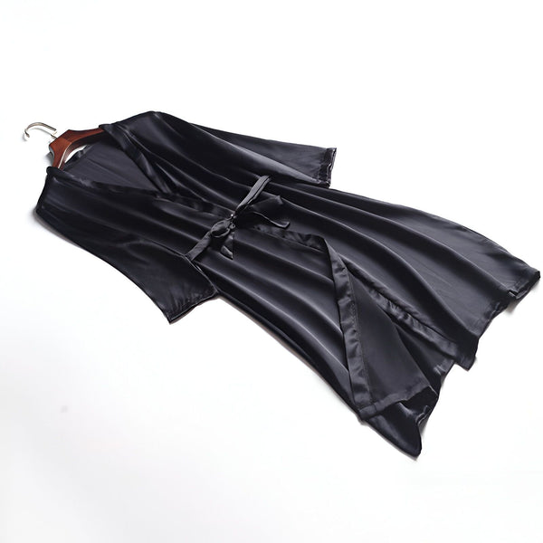 Kimono noir en satin sur un cintre. Élégant peignoir pour femme, idéal pour la détente. Découvrez notre collection de kimonos luxueux.