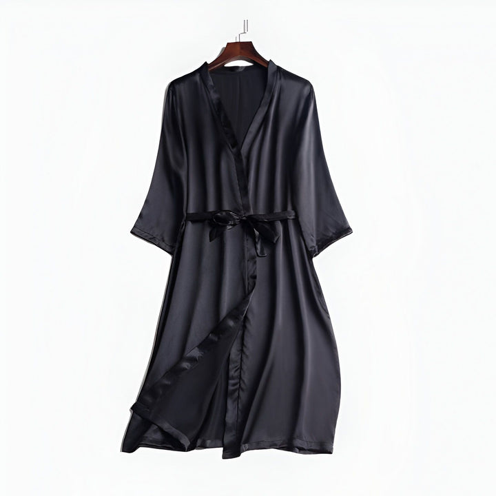 Kimono noir élégant en soie suspendu. Peignoir japonais luxueux avec ceinture, idéal pour se détendre avec style. Vêtements traditionnels revisités.