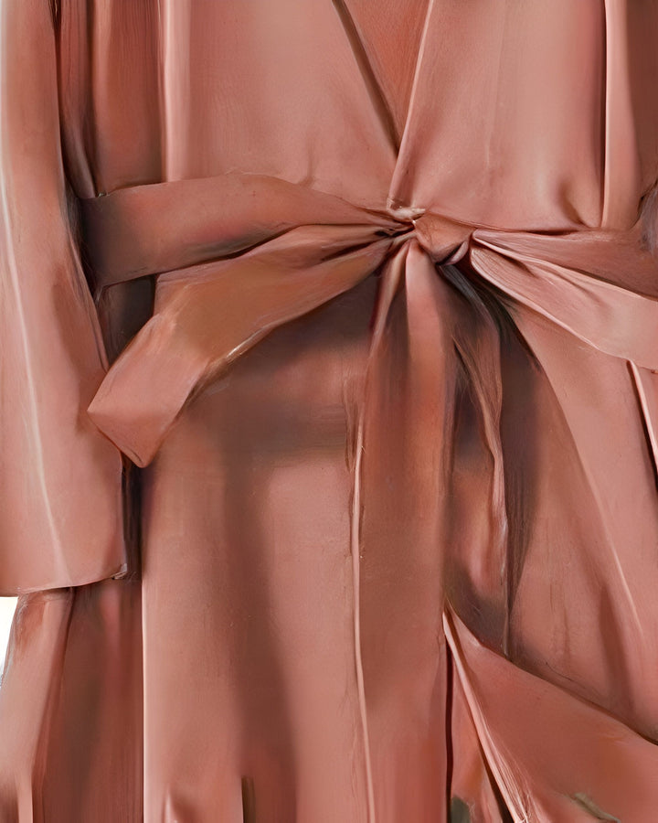 Détail d'un kimono rose pâle en soie avec une ceinture nouée. Vêtements japonais traditionnels revisités. Découvrez notre collection de kimonos élégants.