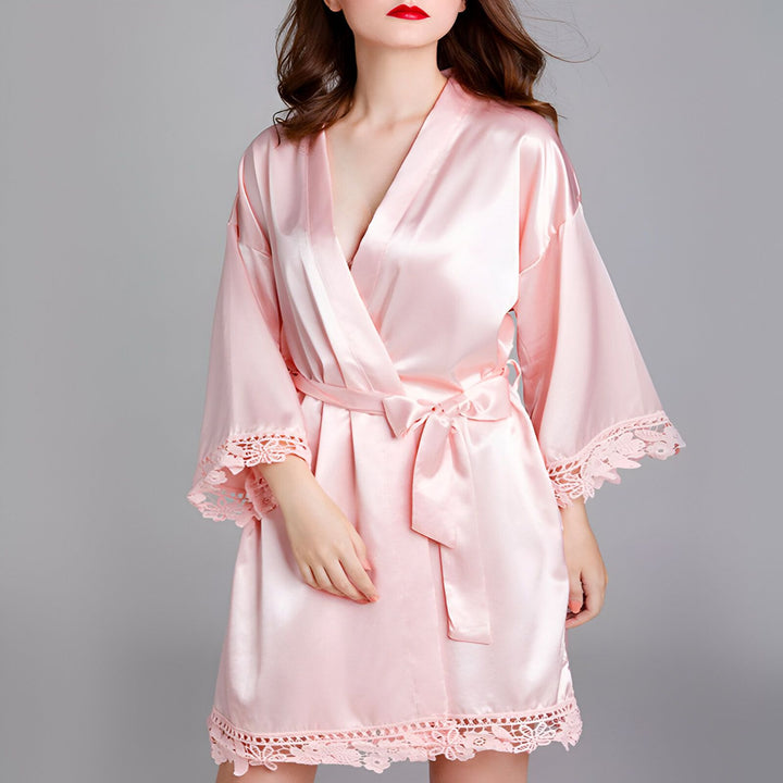 Femme portant un kimono rose en soie avec détails en dentelle. Peignoir style kimono élégant et confortable. Notre collection de kimonos pour femmes.