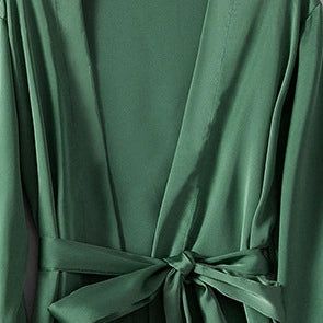 Kimono vert émeraude en satin avec ceinture nouée. Détail du tissu soyeux et de la coupe ample. Vêtements japonais traditionnels et modernes. Découvrez notre collection de kimonos.