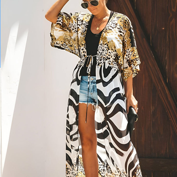 Femme portant un kimono long imprimé léopard et zèbre avec un short en jean et un haut noir. Mode kimono tendance.