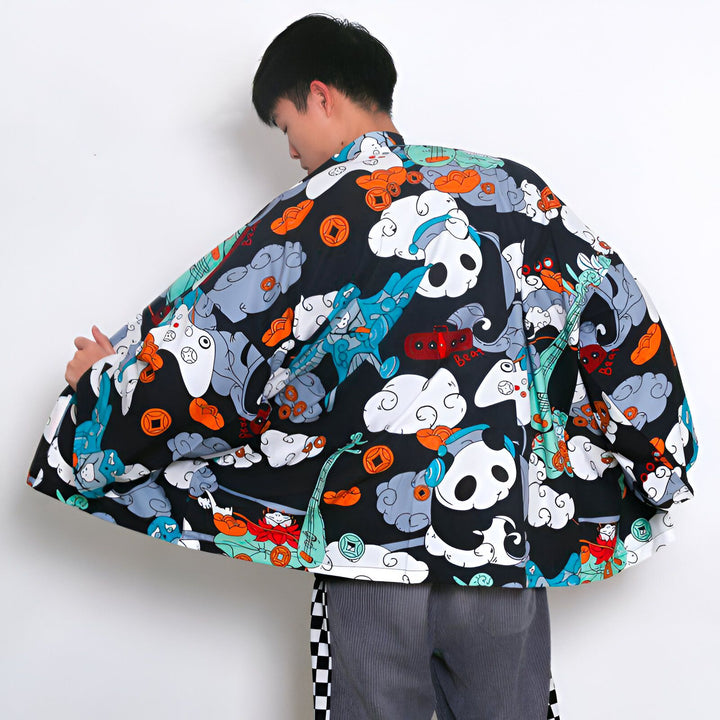 Homme portant un kimono noir à motifs pandas, nuages et symboles japonais. Vêtement ample et confortable, idéal pour un look unique. Découvrez notre collection de kimonos originaux.