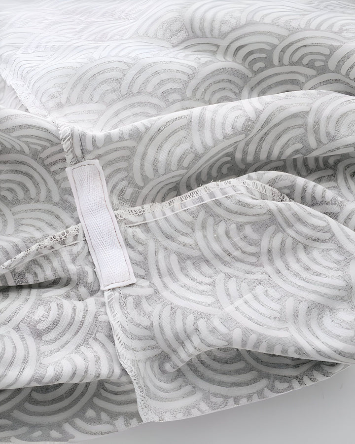 Détail d'un kimono blanc à motifs vagues gris. Texture du tissu et système de fermeture. Découvrez notre collection de kimonos.