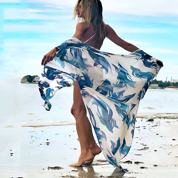Femme sur la plage portant un kimono long à motifs bleus et blancs. Kimonos élégants pour femmes, parfaits pour l'été. Découvrez notre collection de kimonos.