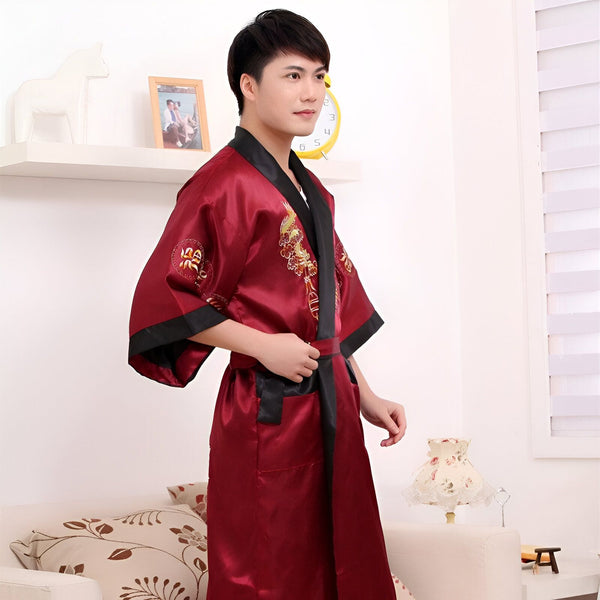Homme portant un kimono bordeaux avec motifs brodés, ceinture noire. Vente de kimonos traditionnels et modernes.