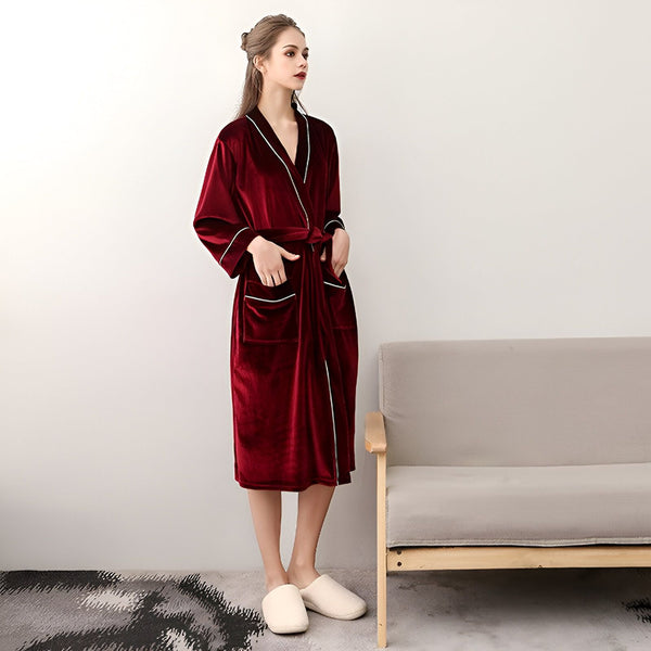 Femme portant un kimono bordeaux en velours avec des finitions blanches. Parfait comme peignoir ou vêtement d'intérieur. Découvrez notre collection de kimonos de qualité.