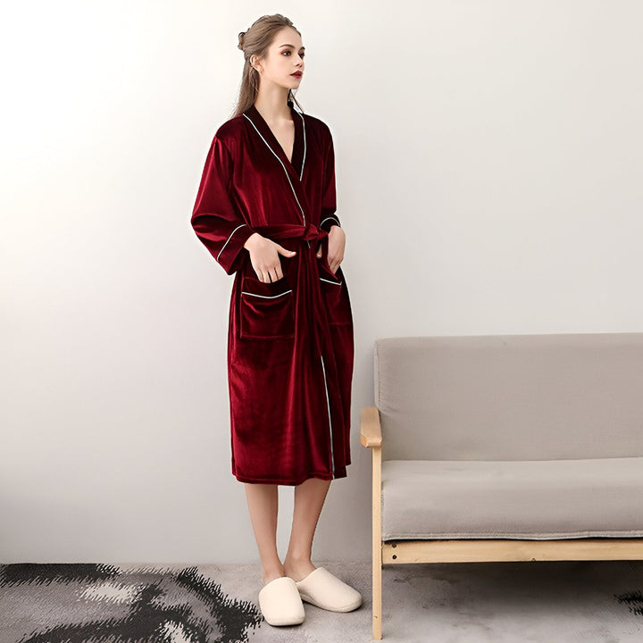 Femme portant un kimono bordeaux en velours avec des finitions blanches. Parfait comme peignoir ou vêtement d'intérieur. Découvrez notre collection de kimonos de qualité.