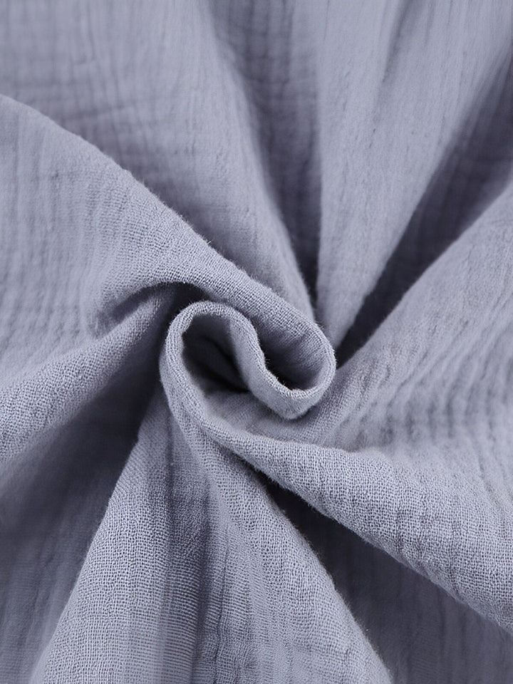 Gros plan sur le tissu texturé d'un kimono. Détails du tissu en coton froissé de couleur grise. Découvrez notre collection de kimonos uniques.