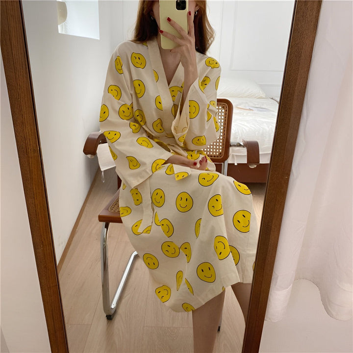 Femme portant un kimono crème à motifs de smileys jaunes. Vente de kimonos originaux et confortables.