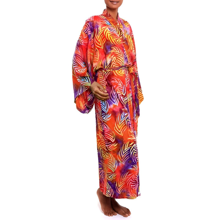 Femme portant un kimono long coloré avec motif de feuilles. Vêtement confortable et élégant. Kimonos disponibles à l'achat.