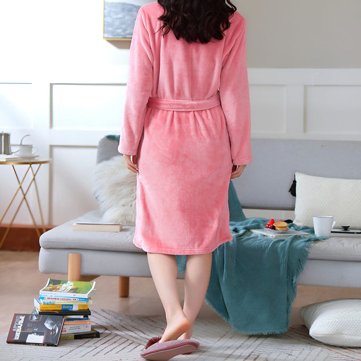 Femme portant un kimono rose confortable avec ceinture, vue de dos. Idéal pour se détendre à la maison. Découvrez notre collection de kimonos pour un style unique.