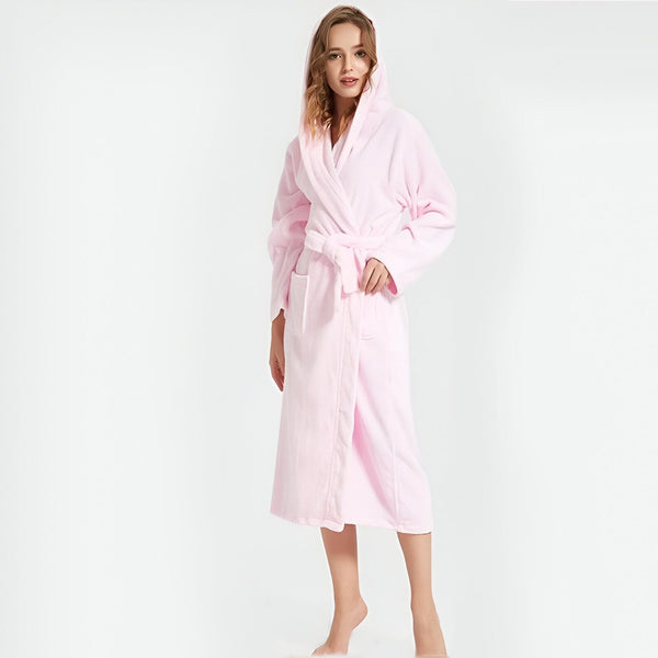 Femme portant un kimono rose doux avec capuche. Peignoir confortable, idéal après le bain ou pour se détendre. Découvrez notre collection de kimonos de qualité.