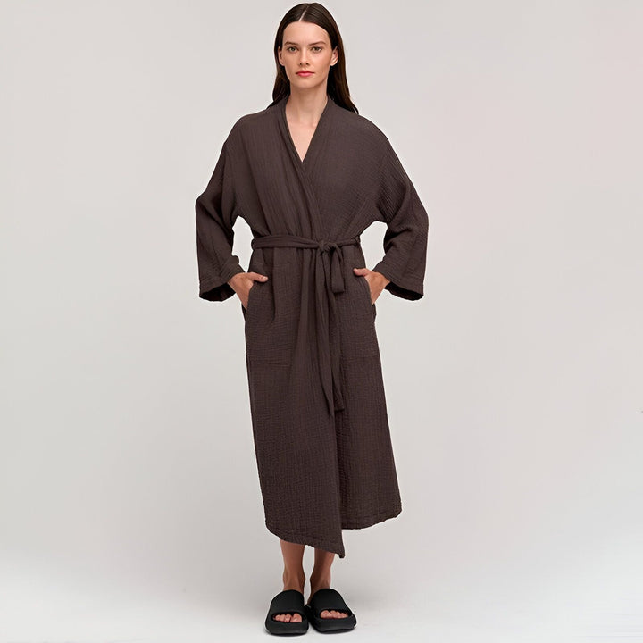 Femme portant un kimono marron en coton avec une ceinture assortie. Peignoir kimono confortable et élégant. Vêtements d'intérieur et de détente. Collection de kimonos.