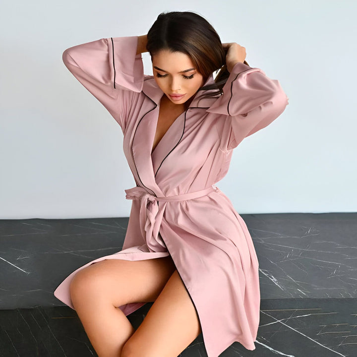 Femme portant un kimono rose avec bordure noire. Vente de kimonos élégants et confortables pour femme. Découvrez notre collection de kimonos en ligne.