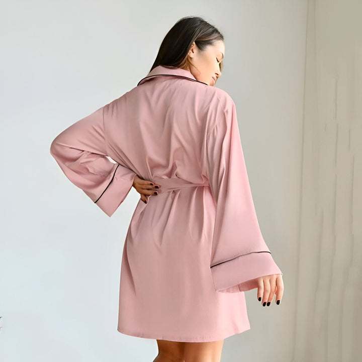 Femme portant un kimono rose avec ceinture. Vêtement d'intérieur confortable et élégant. Kimono à manches longues, idéal pour se détendre. Découvrez notre collection de kimonos uniques.