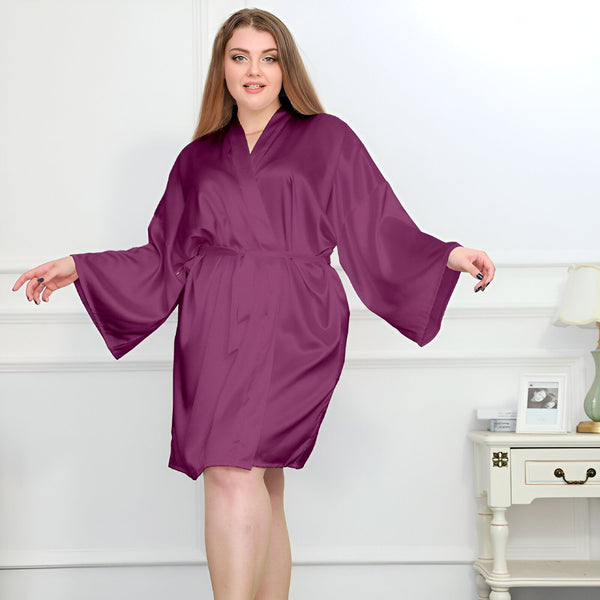 Femme portant un kimono violet en satin, manches larges et ceinture assortie. Kimono élégant et confortable, idéal pour se détendre à la maison. Découvrez notre collection de kimonos de qualité.