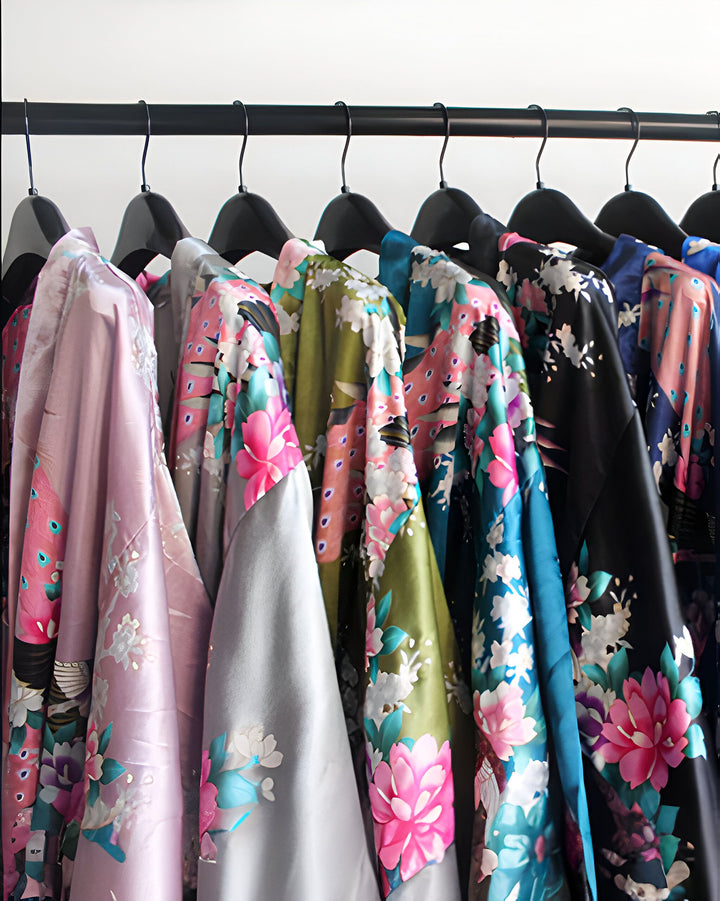 Assortiment de kimonos colorés suspendus à une tringle. Motifs floraux variés. Collection de kimonos élégants et confortables à découvrir.