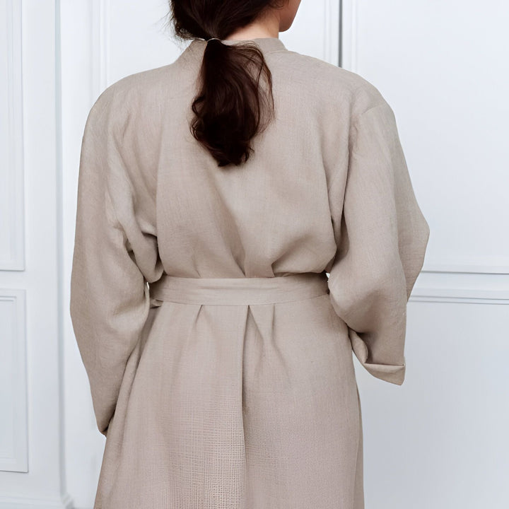 Dos d'une femme portant un kimono beige clair avec une ceinture. Vente de kimonos en ligne.