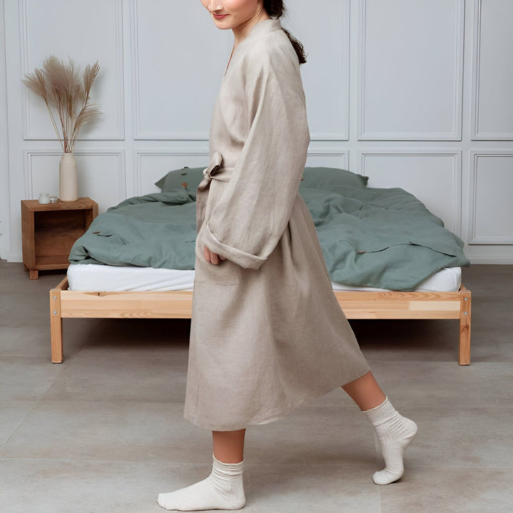 Femme portant un kimono beige en lin dans une chambre. Kimonos confortables et élégants à vendre en ligne.
