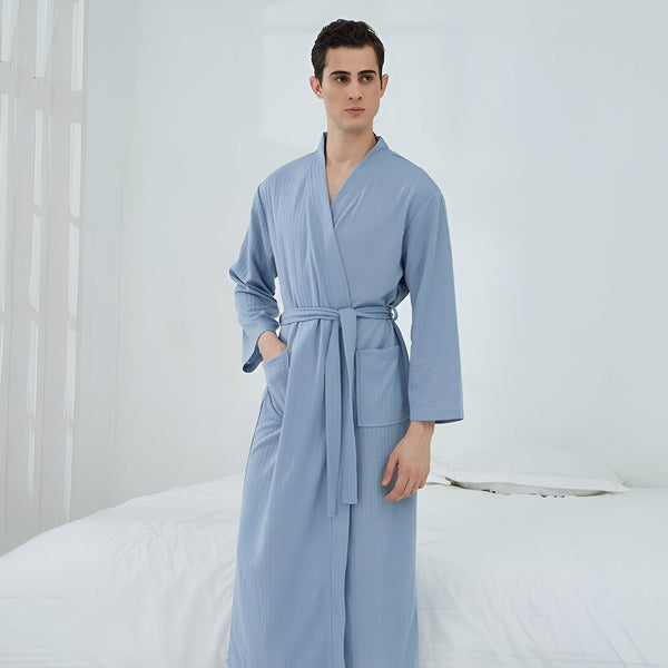 Homme portant un kimono bleu clair avec une ceinture assortie. Vêtements de détente confortables et élégants. Kimonos pour hommes disponibles à l'achat.