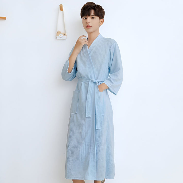 Homme portant un kimono bleu clair, style peignoir, avec une ceinture nouée. Vente de kimonos en ligne.